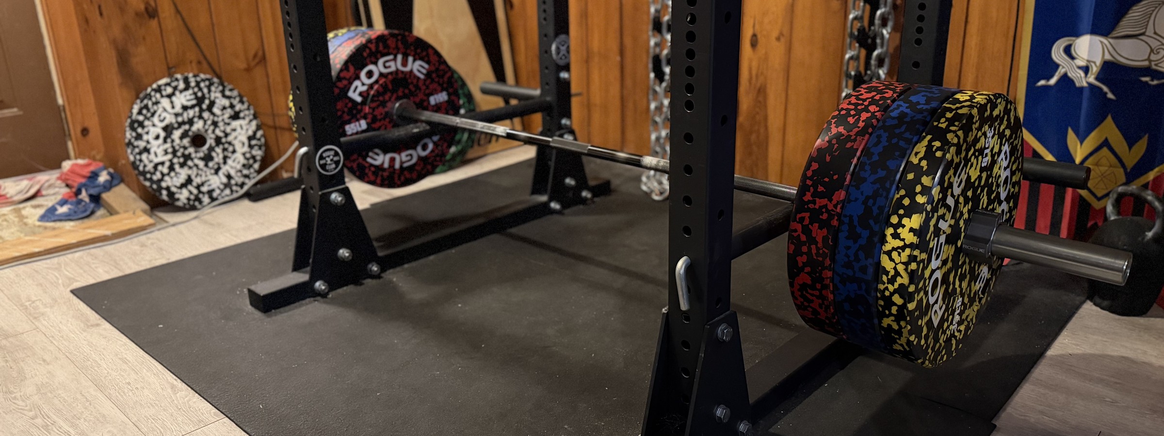 A loaded barbell racked in a home gym